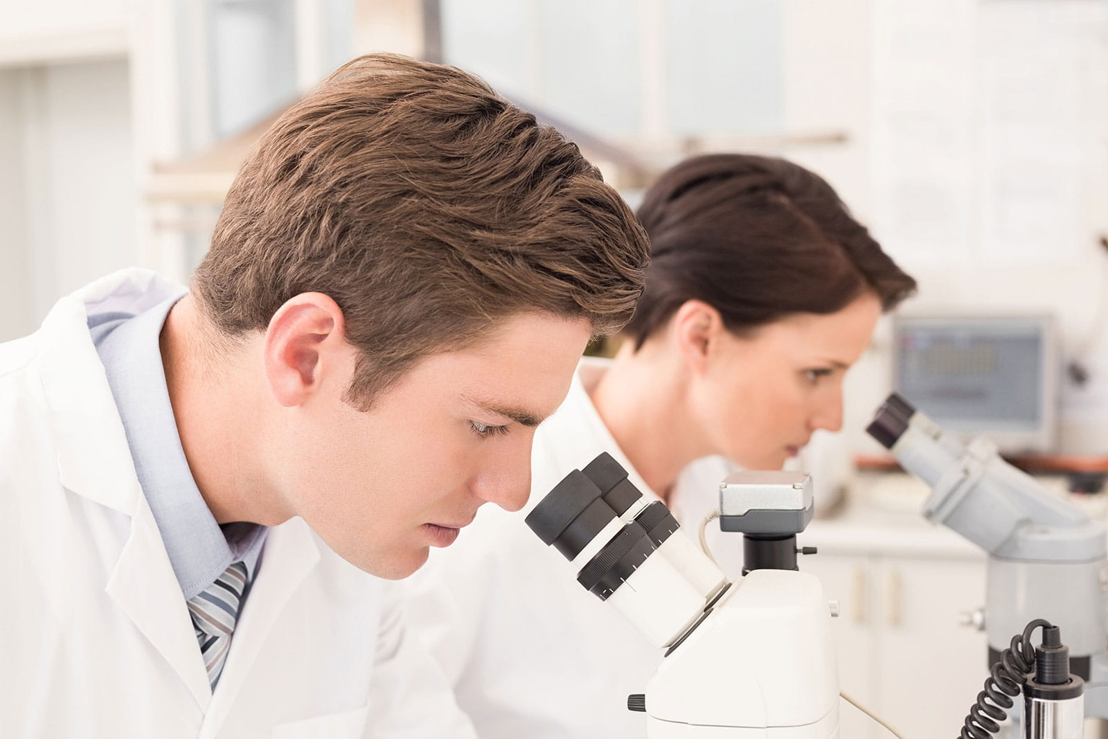 deux chercheurs à la recherche dans un microscope